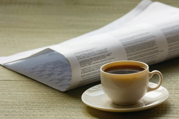 Coffee cup and newspaper.