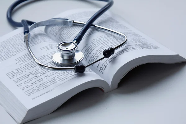 A medical stethoscope on an open book