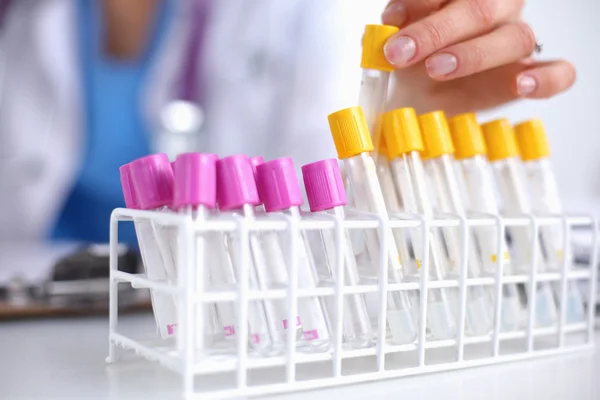 Woman researcher is surrounded by medical vials and flasks, isolated on white background