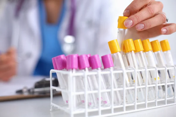 Woman researcher is surrounded by medical vials and flasks, isolated on white background