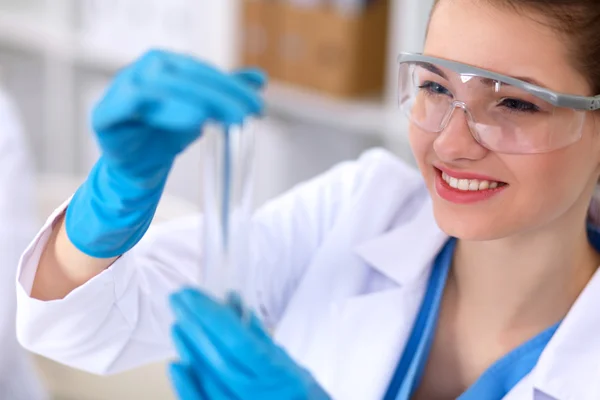 Woman researcher is surrounded by medical vials and flasks, isolated on white background