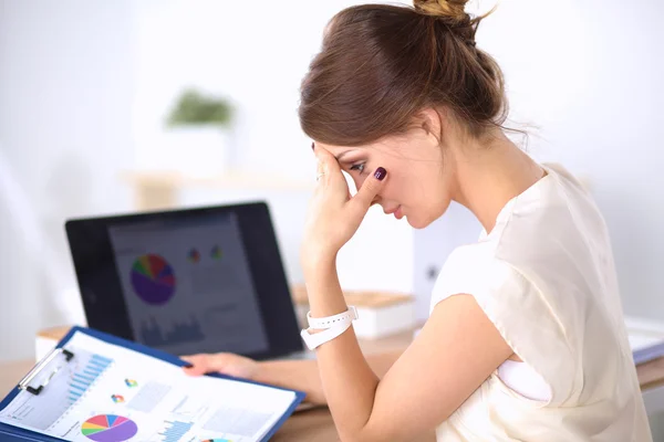 Portrait of tired young business woman with laptop computer at the office