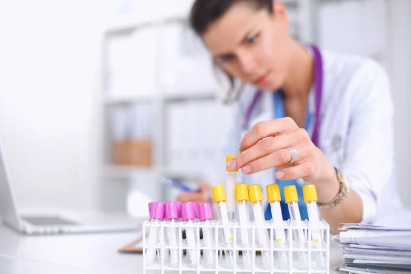 Woman researcher is surrounded by medical vials and flasks, isolated on white background