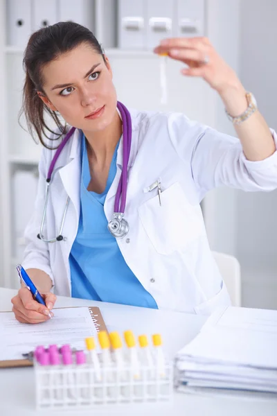 Woman researcher is surrounded by medical vials and flasks, isolated on white background