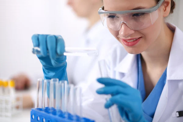 Woman researcher is surrounded by medical vials and flasks, isolated on white background