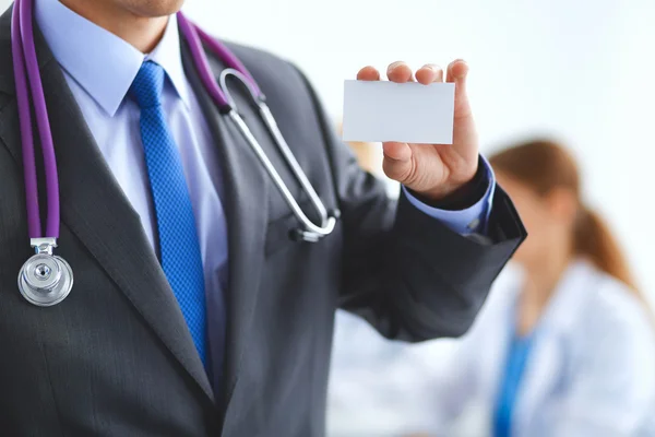 Male doctor holding blank white card