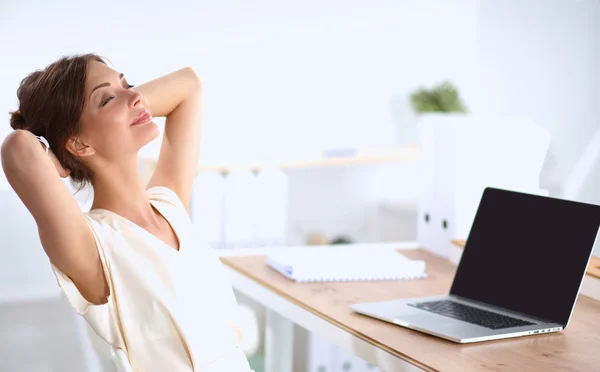 Business woman  relaxing with  hands behind her head and sitting on an office chair