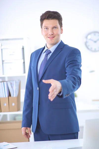 Business and office concept - businessman with open hand ready for handshake