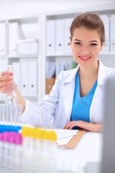 Woman researcher is surrounded by medical vials and flasks, isolated on white background