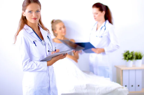 Smiling female doctor with a folder in uniform standing at hospital