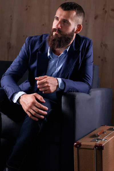 Businessman sitting the sofa in office lobby, isolated on dark background