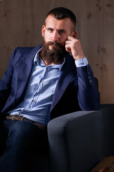 Businessman sitting the sofa in office lobby, isolated on dark background