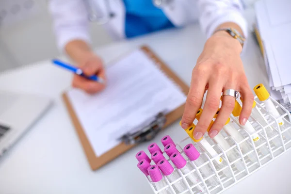 Woman researcher is surrounded by medical vials and flasks, isolated on white background