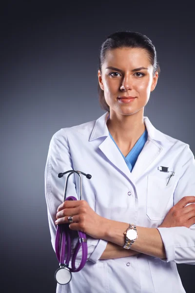 Young doctor woman with stethoscope isolated on grey