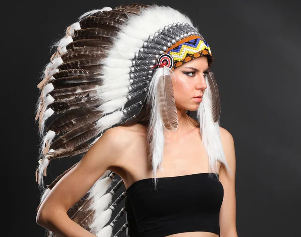 Beautiful woman in native american costume with feathers