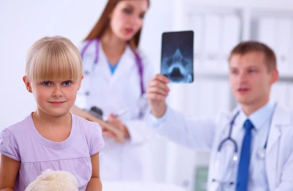 Female doctor examining child with stethoscope at surgery