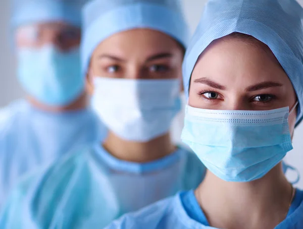 Surgeons team, wearing protective uniforms,caps and masks