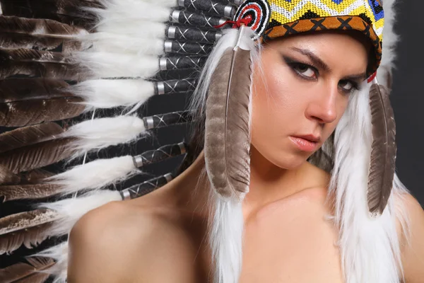 Beautiful woman in native american costume with feathers