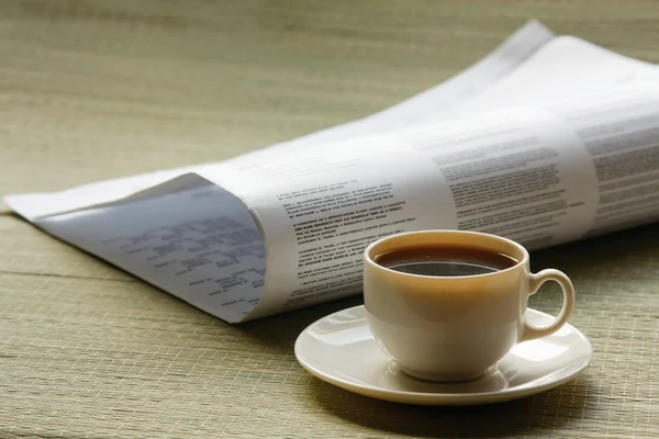 Coffee cup and newspaper.