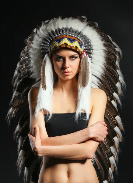 Beautiful woman in native american costume with feathers