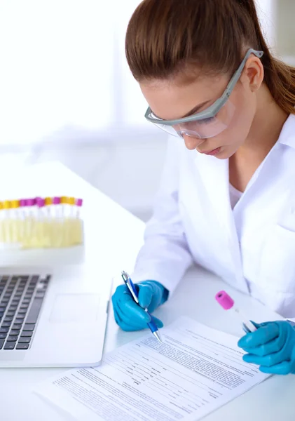 Woman researcher is surrounded by medical vials and flasks, isolated on white background