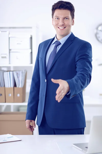 Business and office concept - handsome businessman with open hand ready for handshake