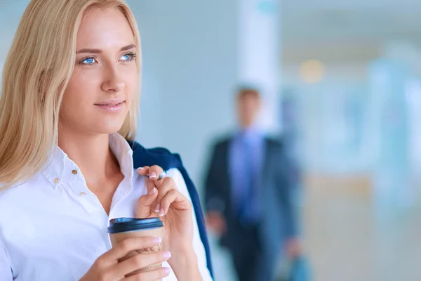Yound woman drink coffee at office, standing