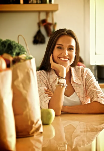 Young woman sitting near desk in the kitchen