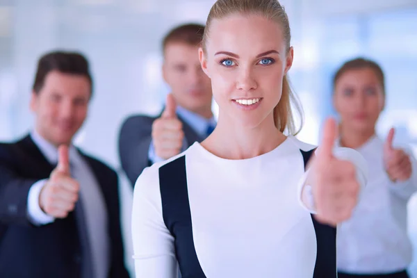 Happy business team showing thumbs up in office