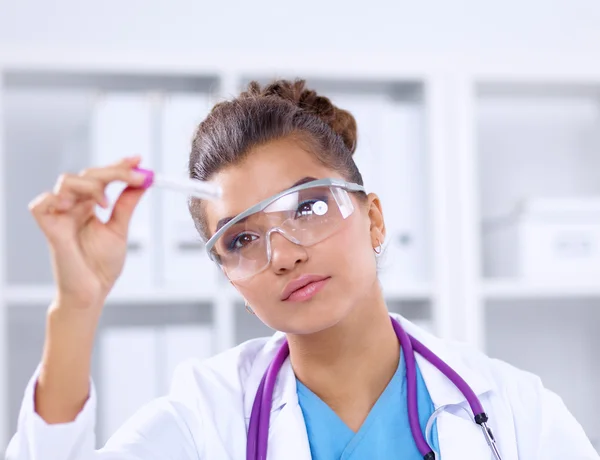 Woman researcher is surrounded by medical vials and flasks, isolated on white background