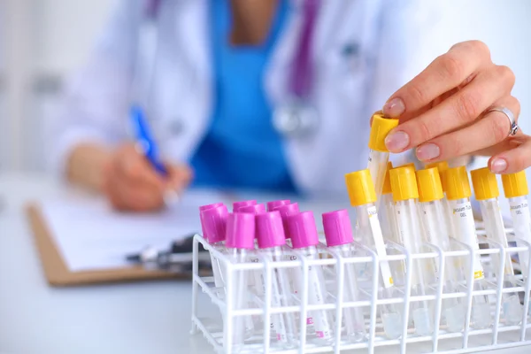 Woman researcher is surrounded by medical vials and flasks, isolated on white background