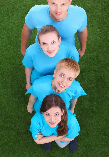 Group of young  people standing on green grass