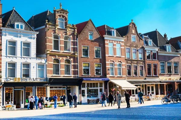 Colorful street view with houses and people in Delft, Holland