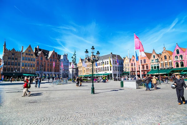 Square with colorful traditional houses, people walking in Bruges, Belgium