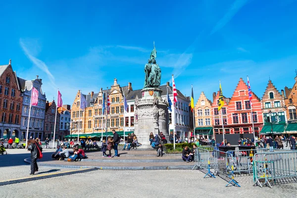 Square with colorful traditional houses, people walking in Bruges, Belgium