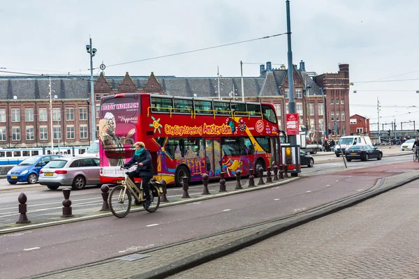 Red sightseeing tour bus and historic houses in Amsterdam, Netherlands