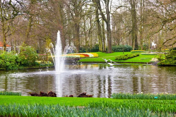 Lake and fountain in the spring flower garden