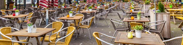 Panorama with European street cafe or restaurant tables