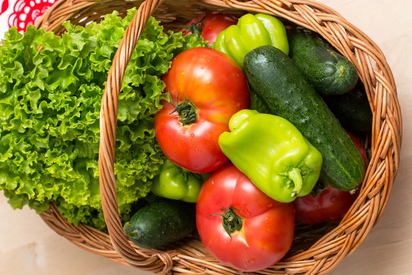 Fresh vegetables in basket. Tomato, cucumber, pepper and lettuce