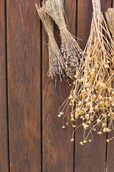 Bunches of dried herbs on an old brown wooden background