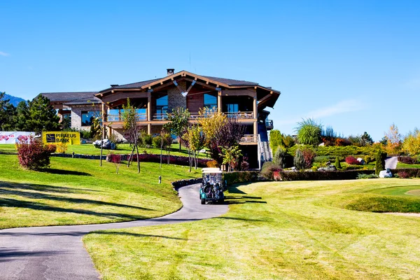 Pirin Golf Club house and restaurant, colorful autumn trees, golf cart, blue sky