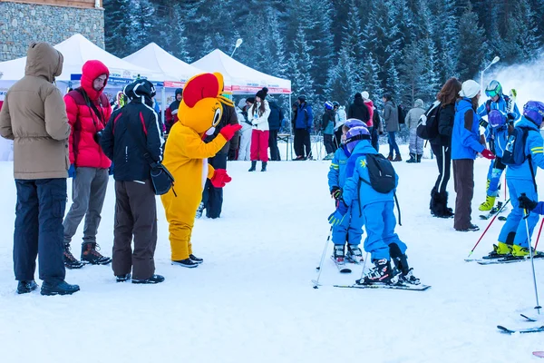 Young skiers preparing to ski and Mouse in Costume, Bansko, Bulgaria
