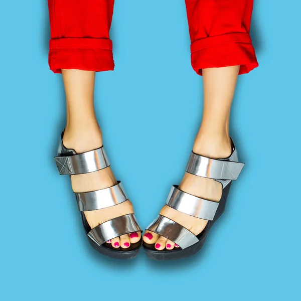 Female legs wearing summer shoes