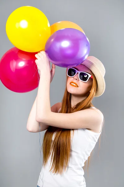 Red hair woman with colored balloons