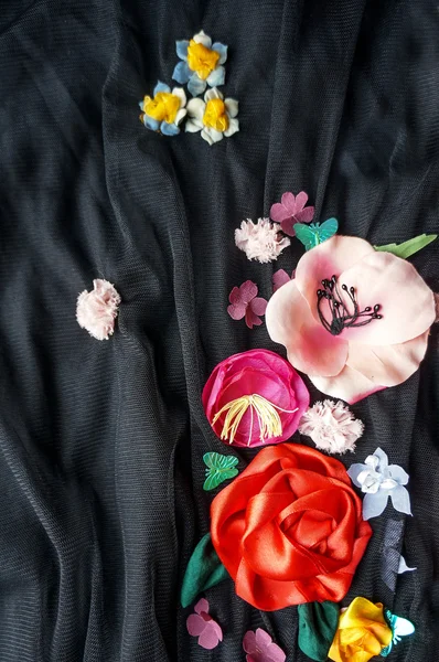 Colorful silk flowers over black background