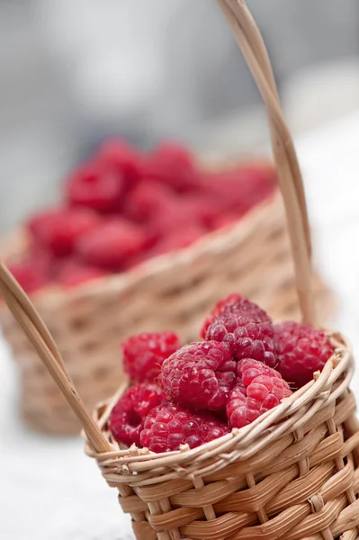 Ripe sweet raspberries in small wicker basket.