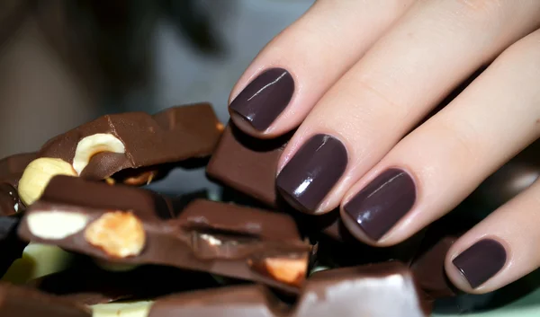 Beautiful woman hand with pieces of milk chocolate