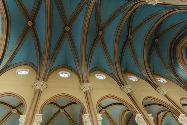 High beige columns and vaulted blue ceiling