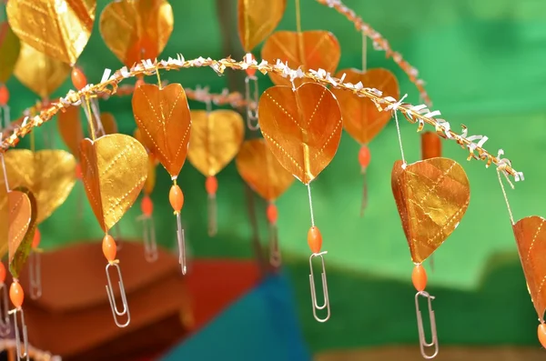 Buddhist golden money tree with hearts instead of leaves and paper clips for banknotes