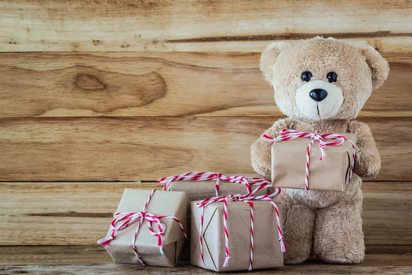 Teddy bear holding a gift box